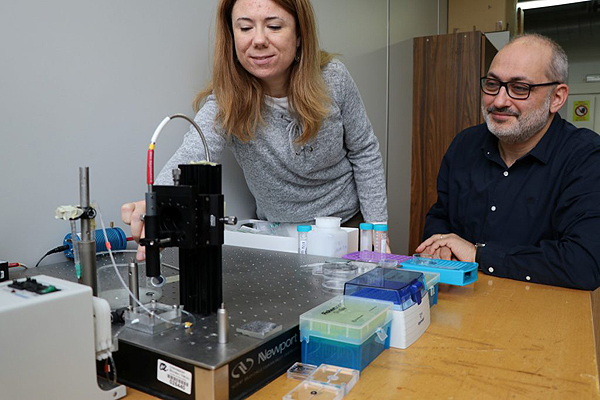 Los investigadores Elisabet Xifré y Lluís Marsal, ante el aparato de espectroscopia de reflectancia interferométrica que han utilizado para desarrollar el sensor, un método óptico que permite detectar niveles de señal ínfimos Fuente: URV