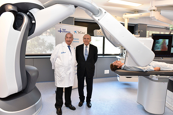 El Dr. Josep Ramon Armengol (a la izq. de la imagen) e Isidre Fainé, presidente de la Fundación Bancaria ‘la Caixa’, posando bajo el nuevo robot